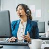 Friendly woman in call center service talking with costumers by headset. Call center and diverse people group in business.